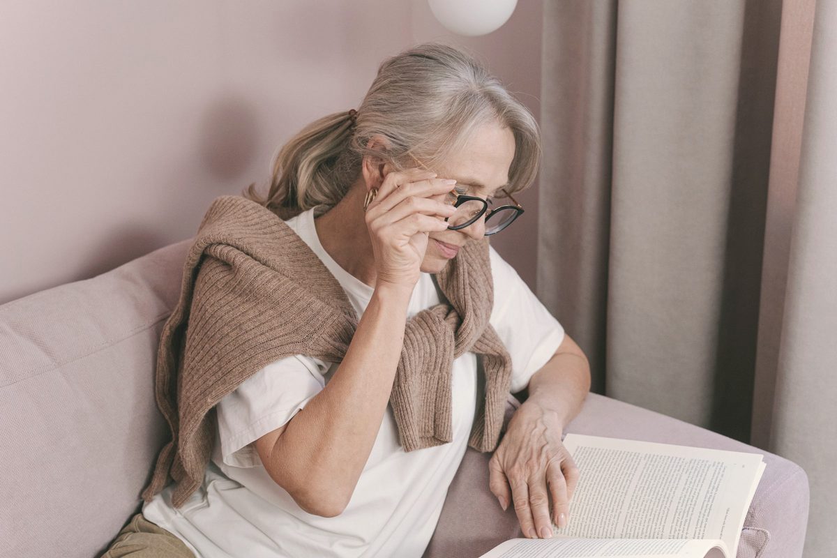 Older woman with grey hair reading a book