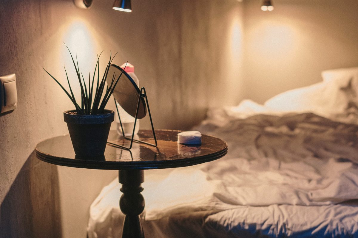 Bedside table and lamp in a bedroom in the evening