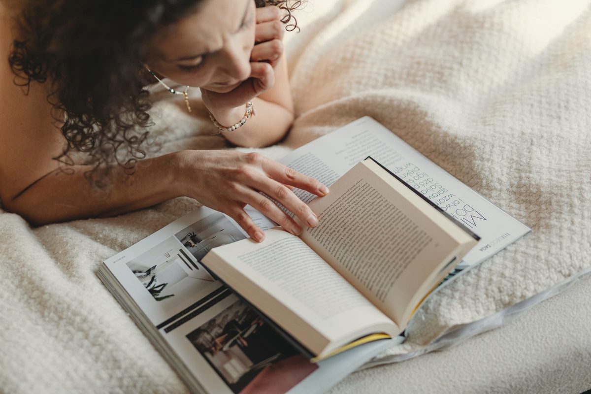 Woman reading a book on a bed