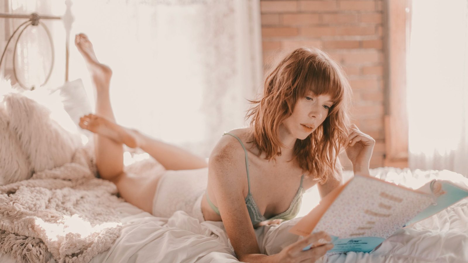 Woman reading book on bed