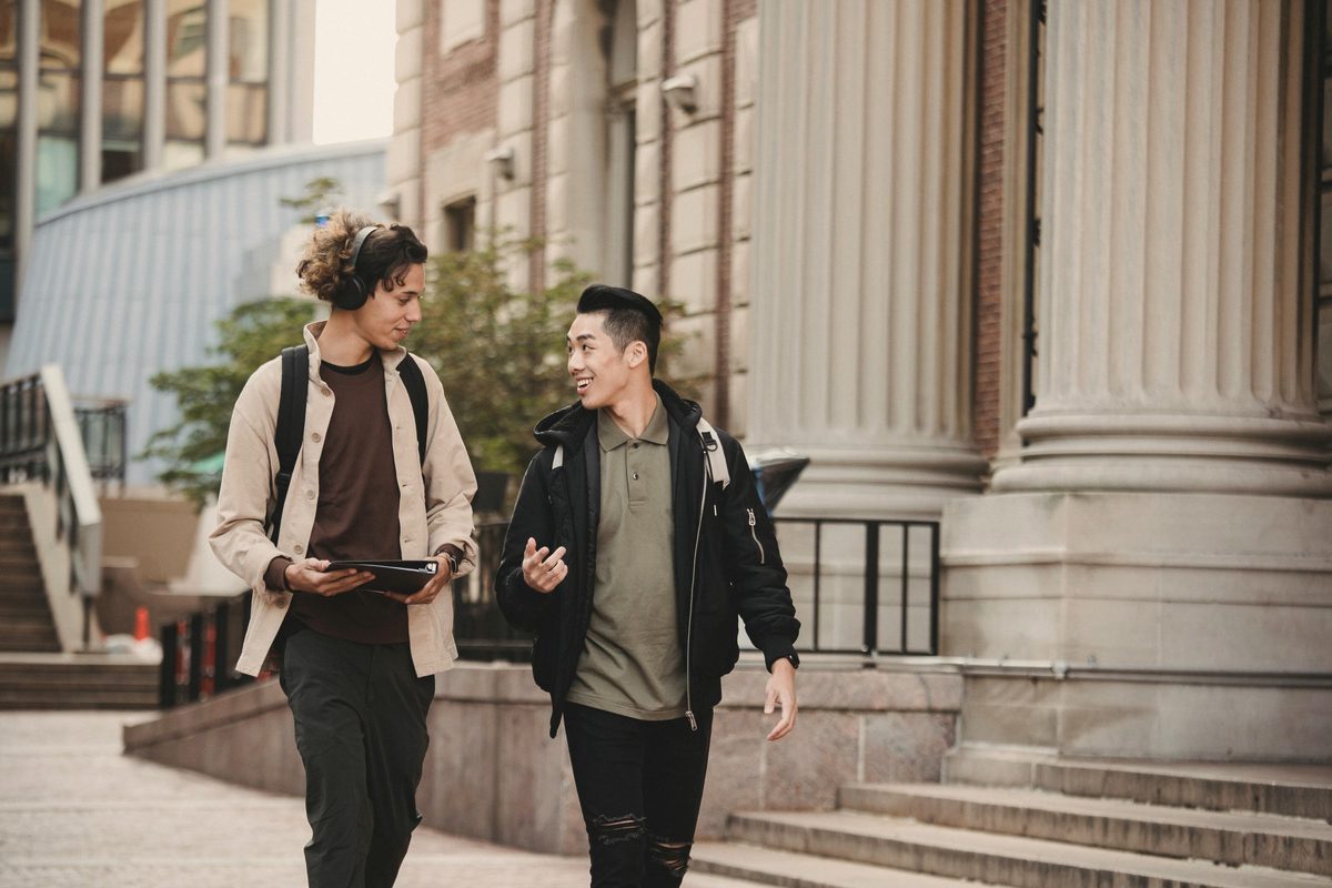 Male friends talking while walking down street
