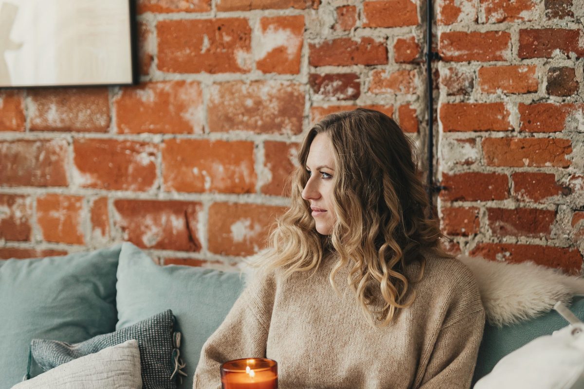 Woman relaxing on a sofa wrapped in a blanket