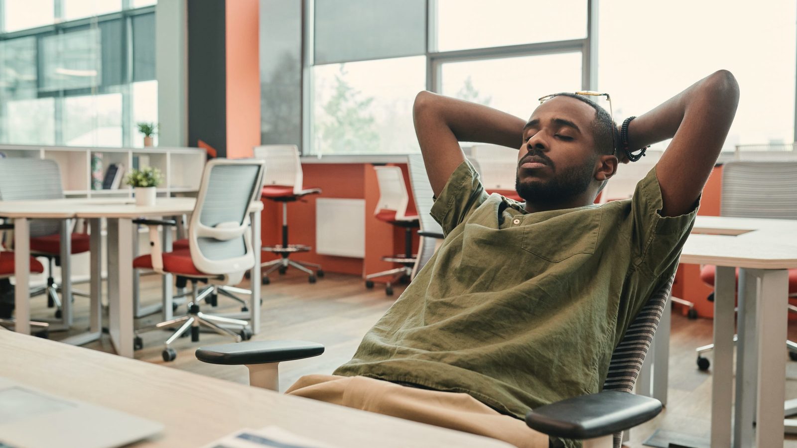 Man taking a short rest in his office chair with his eyes closed