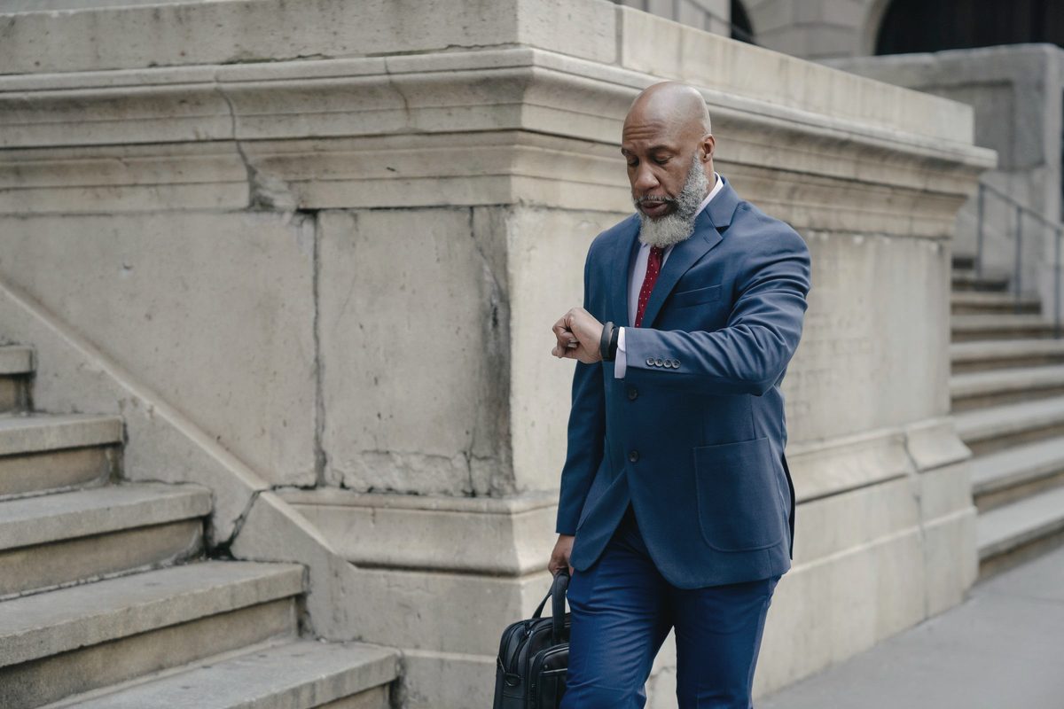 Serious man in formal suit looking at wristwatch