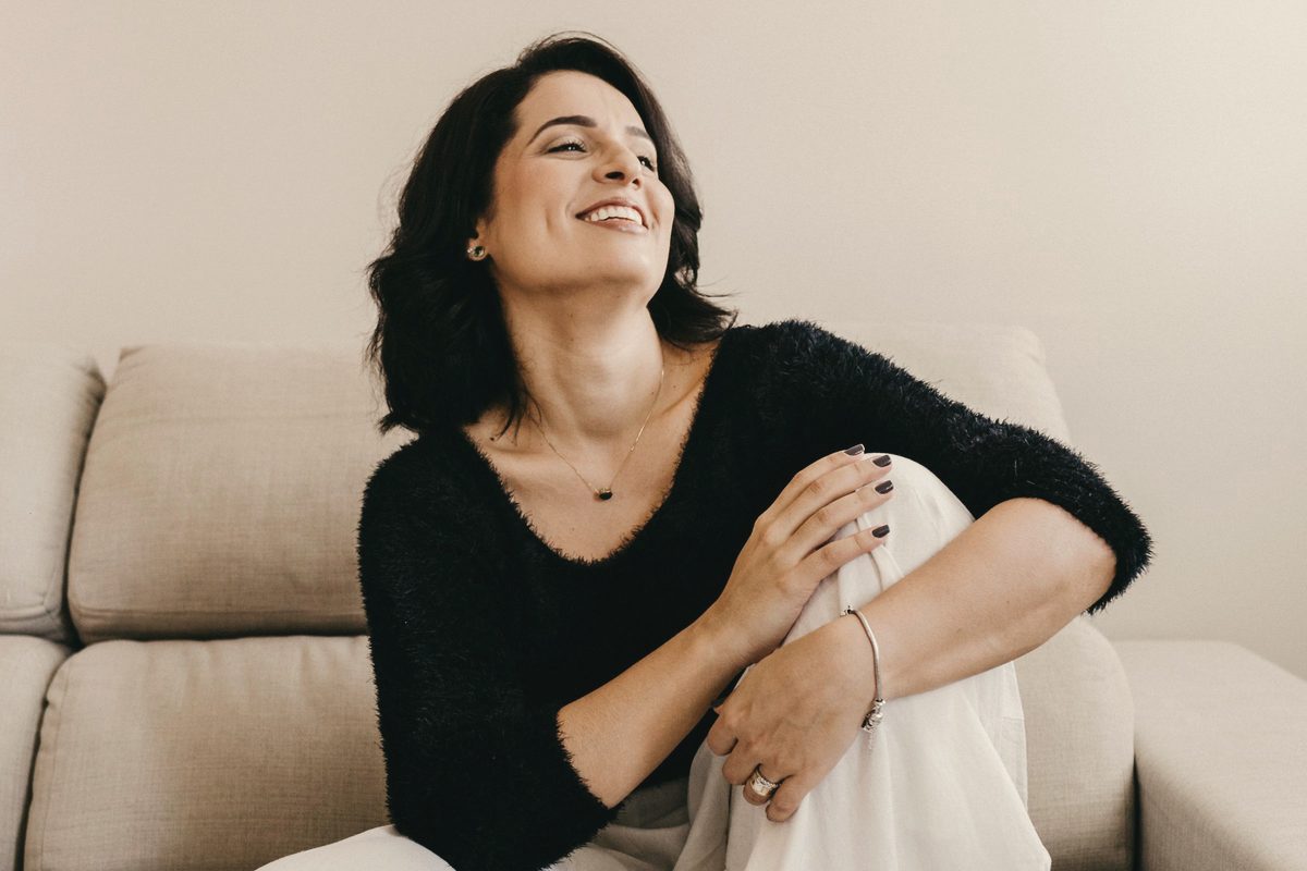 Happy woman resting on sofa in flat