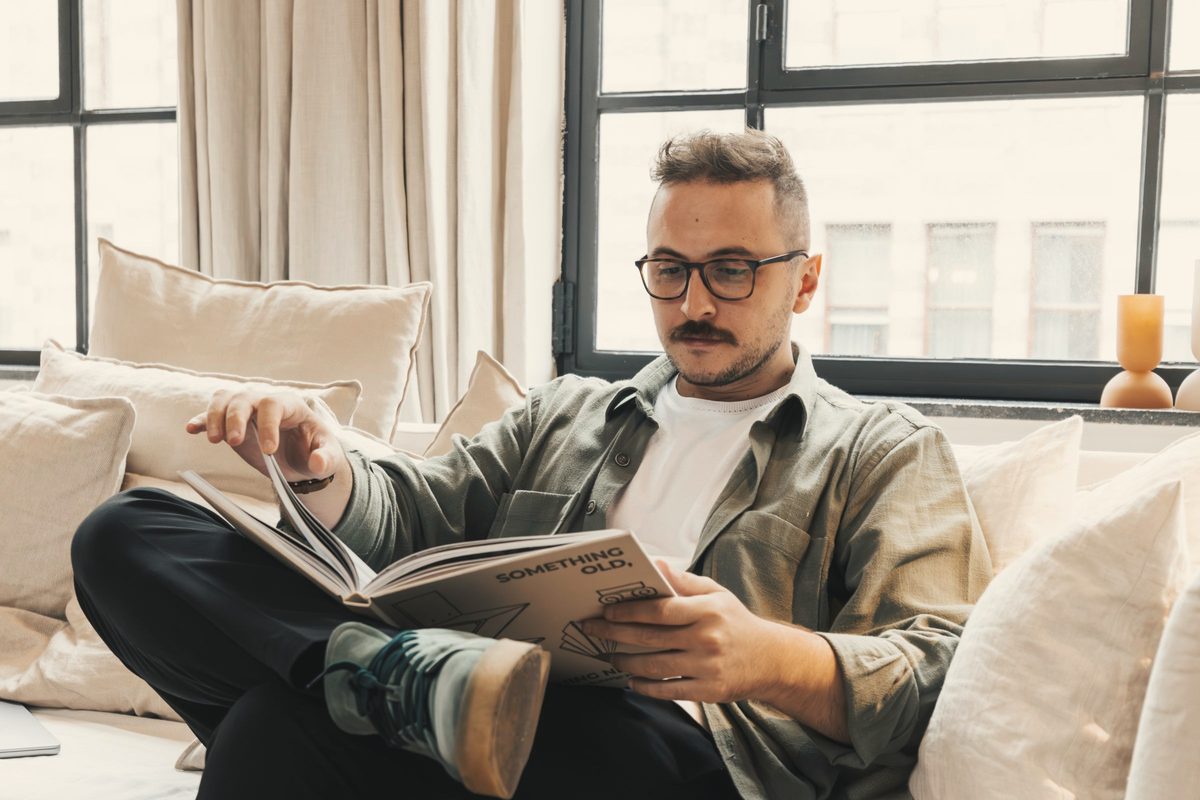Man sitting on sofa and reading book