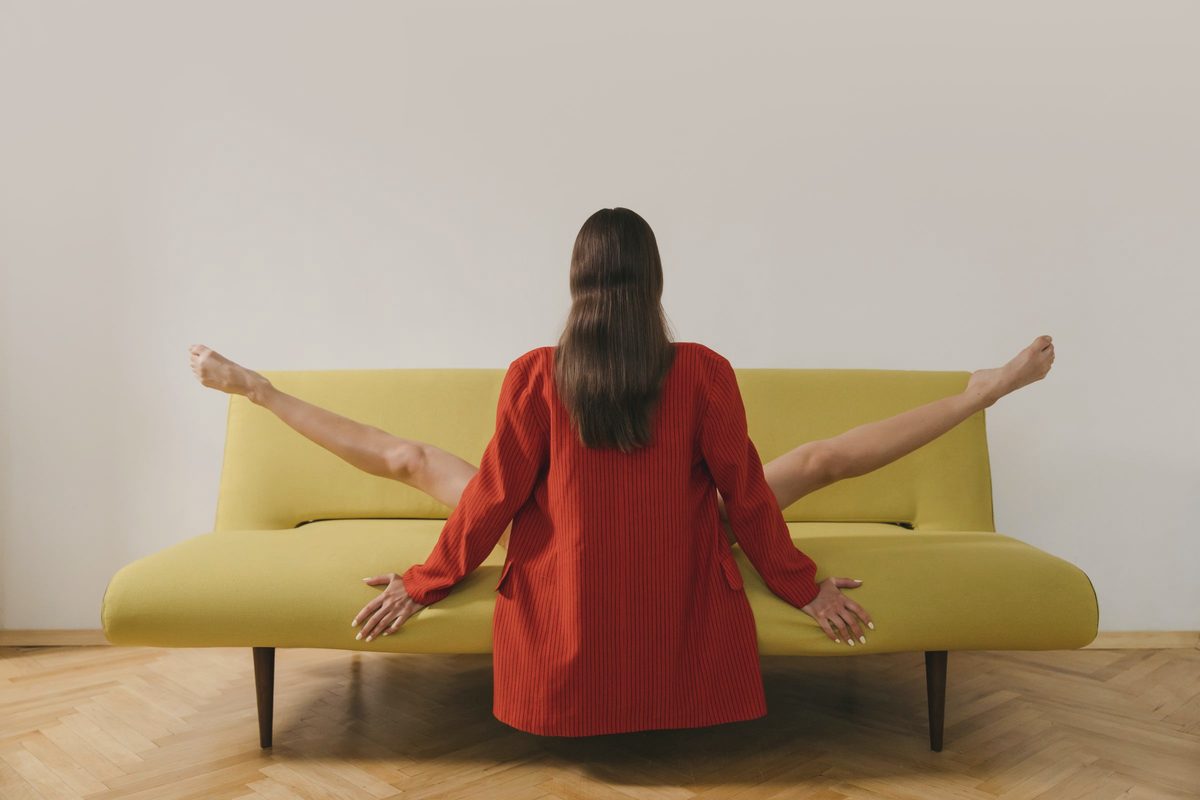 Woman stretching her legs while sitting on a couch