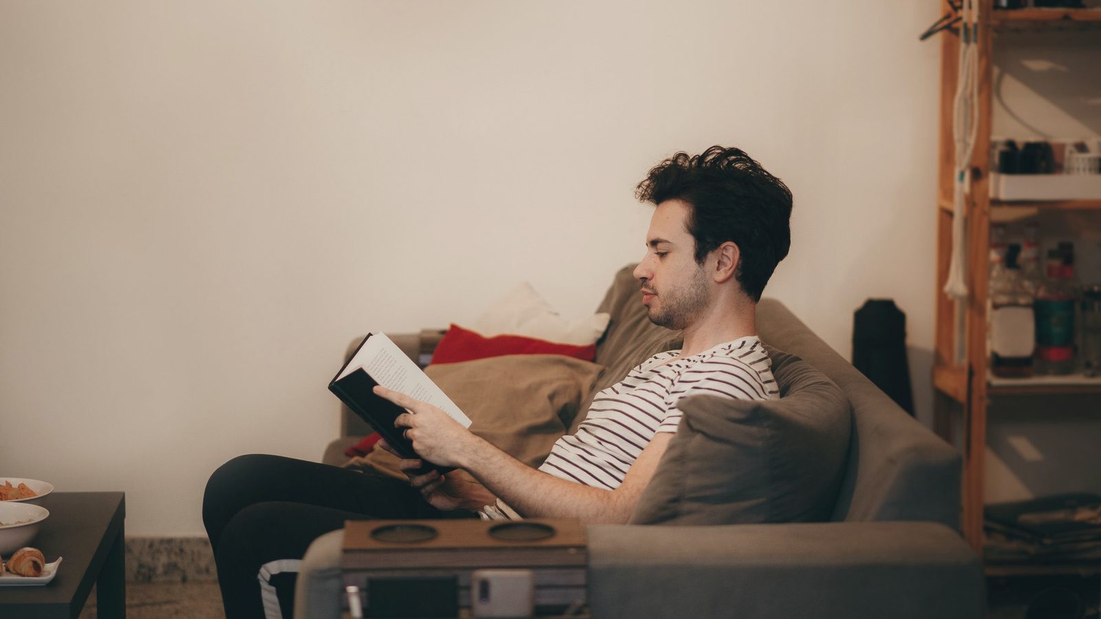 Man reading book on sofa