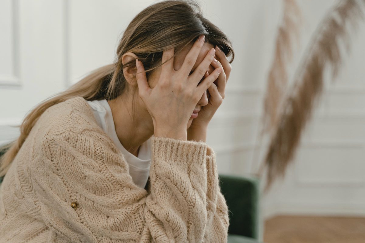 Woman covering her face with her hands