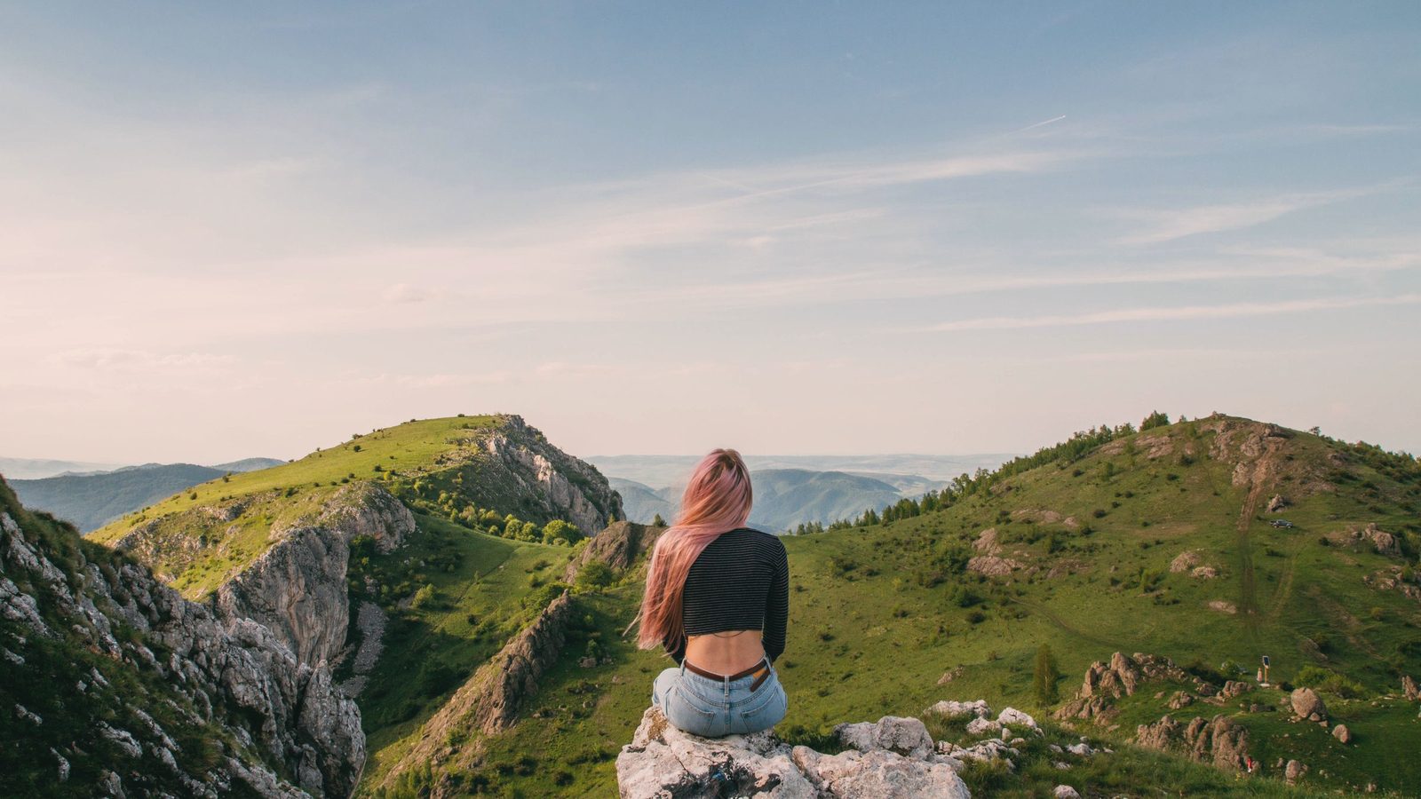 Woman sitting on a rock overlooking the mountains