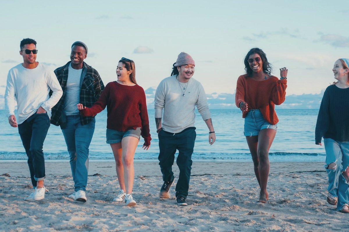 Group of friends walking together along the beach
