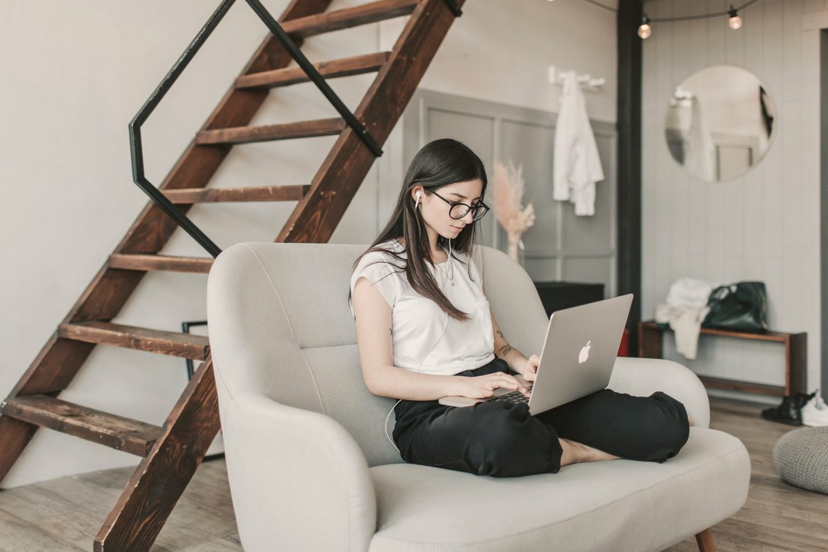 Woman working on her laptop in a bright armchair