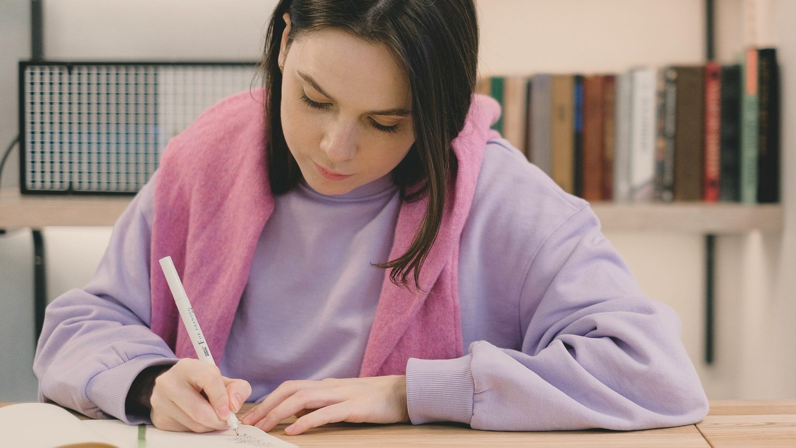 Student writing in her notebook at a desk