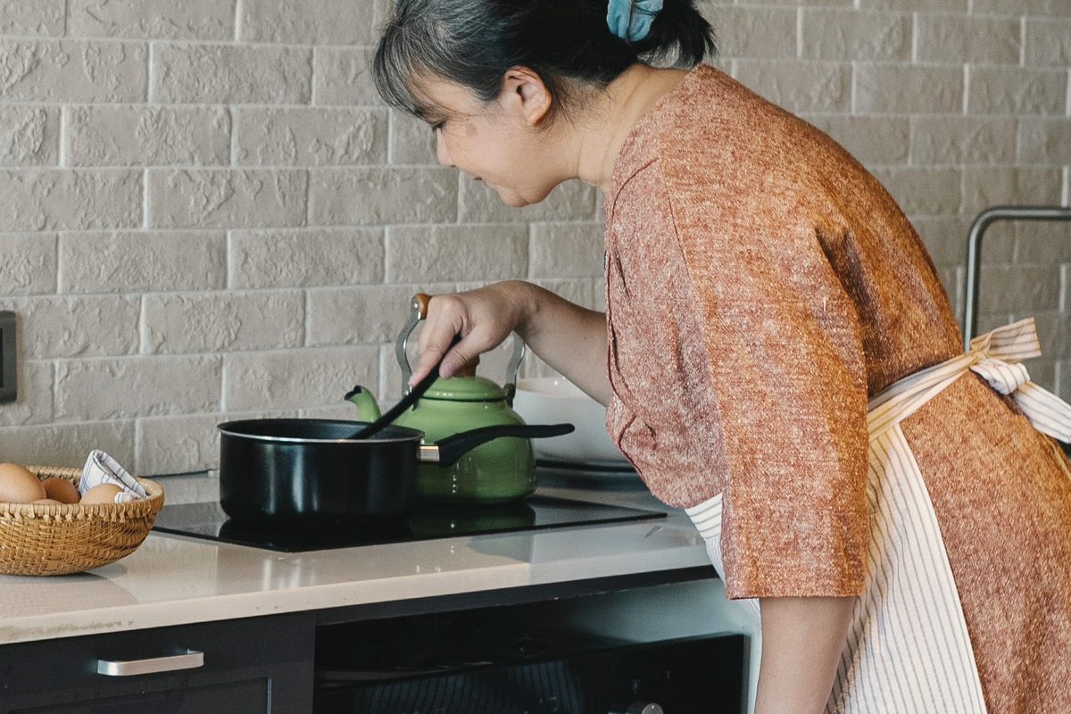 Senior woman cooking dinner in modern kitchen
