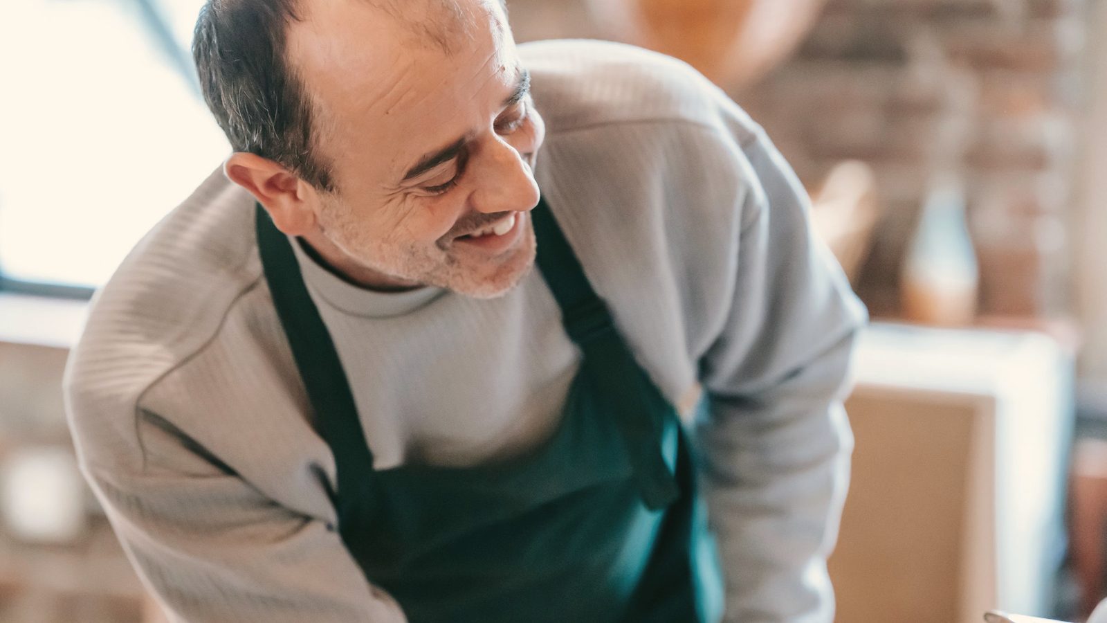 Cheerful man cooking in light kitchen