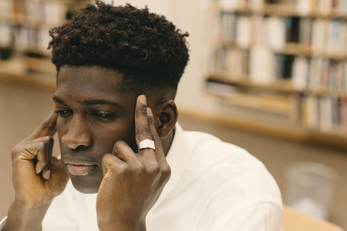 Man resting his fingers on his temples while thinking