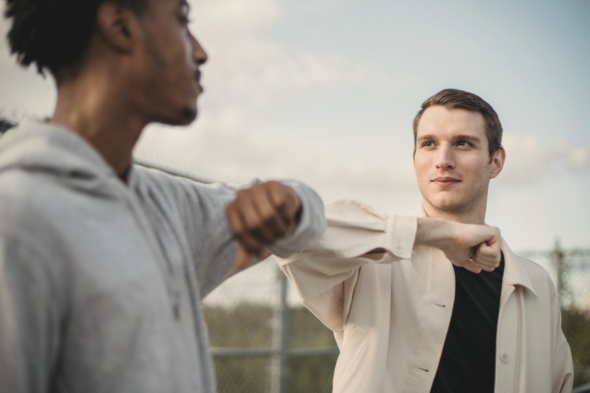 Friends greeting each other with an elbow bump