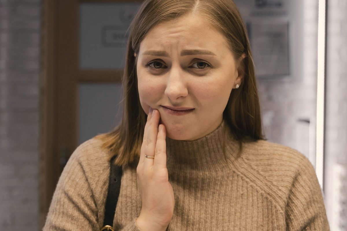 Woman holding her jaw in discomfort