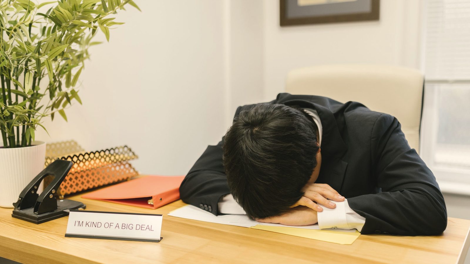 A man in a suit sleeping on the desk