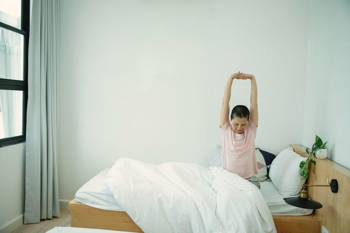 Woman stretching on bed in the morning