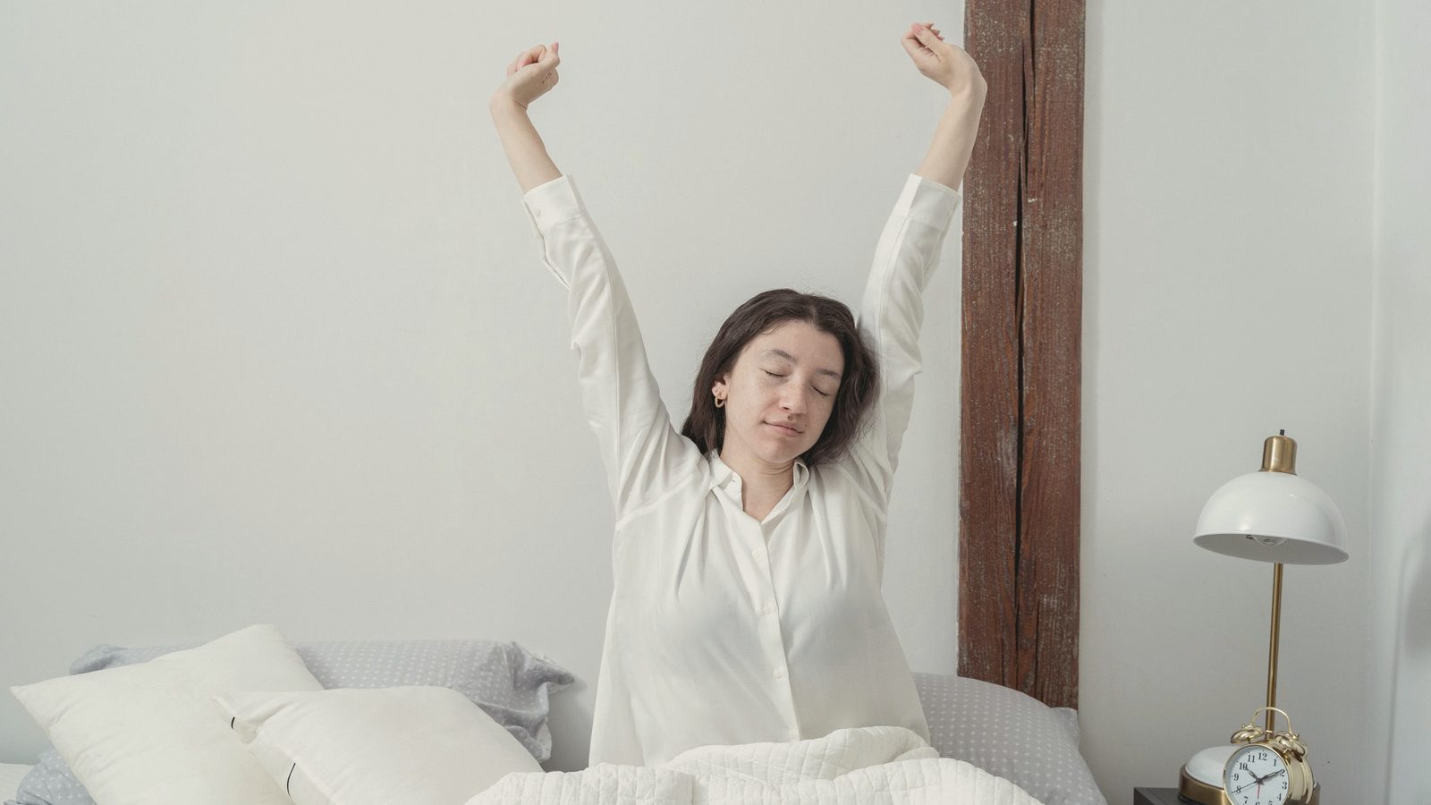 Sleepy woman waking up on bed in morning