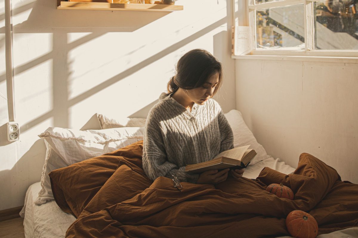 Woman sitting in bed reading a book