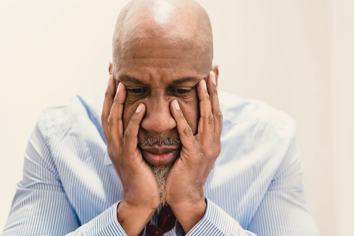 Worried man holding his face in his hands