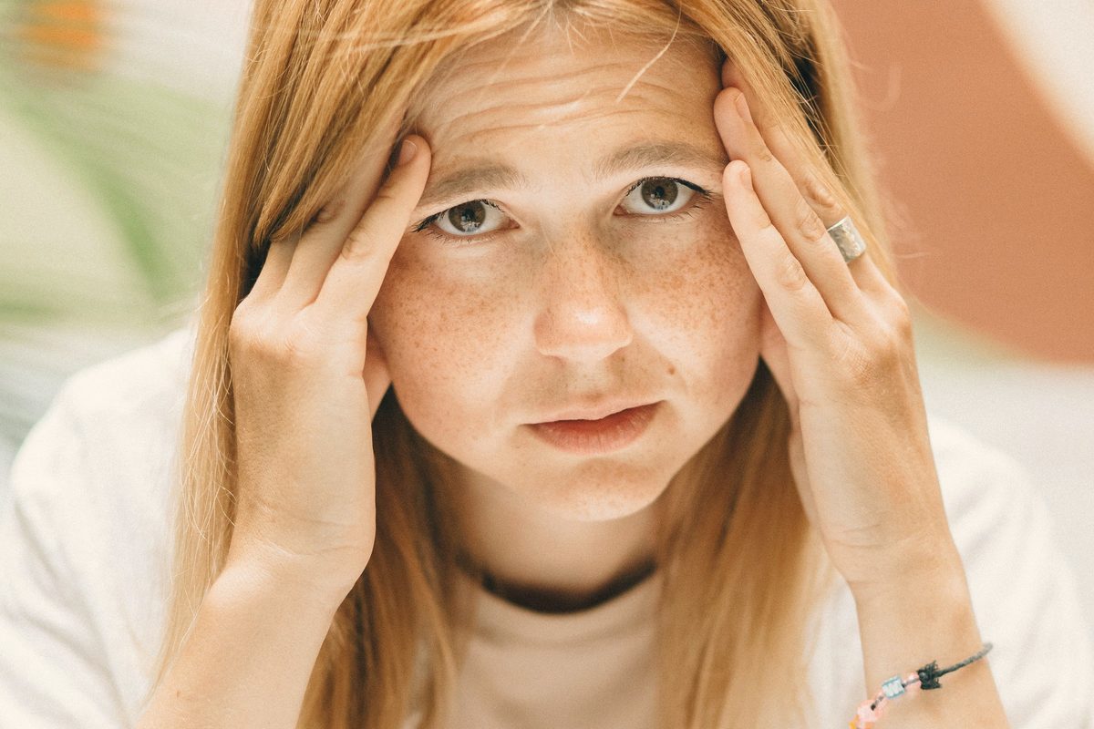 Stressed woman pressing her hands to her temples
