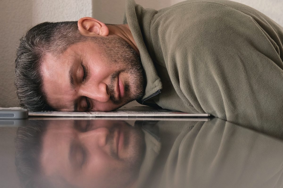 Exhausted man resting his head on his desk