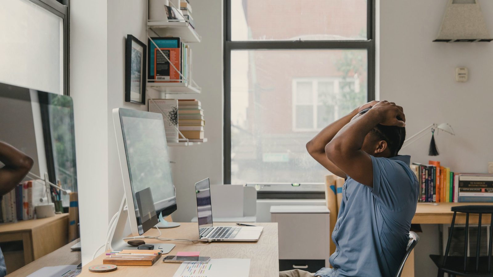 Man with hands on head in office