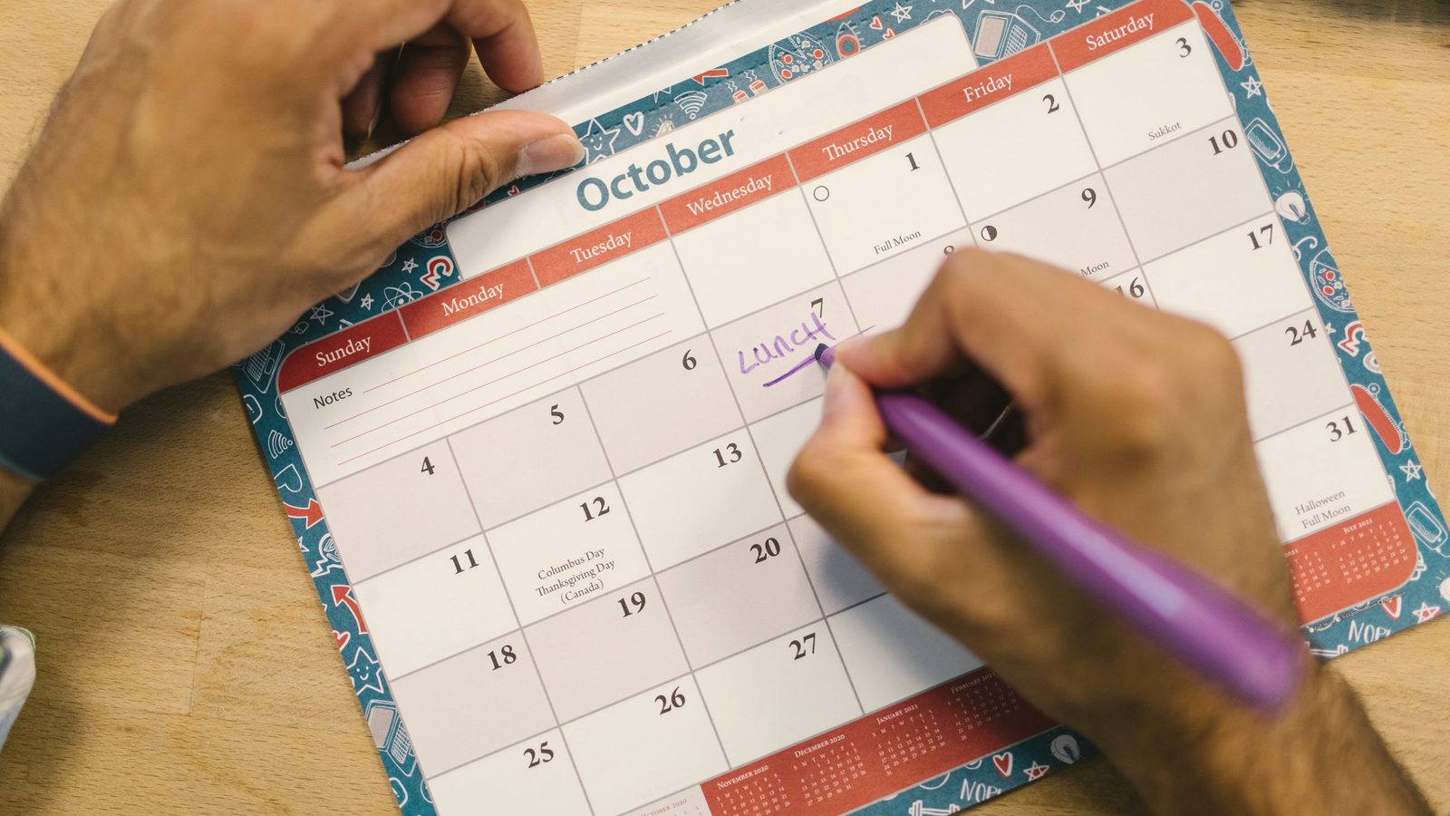 Person writing on a calendar