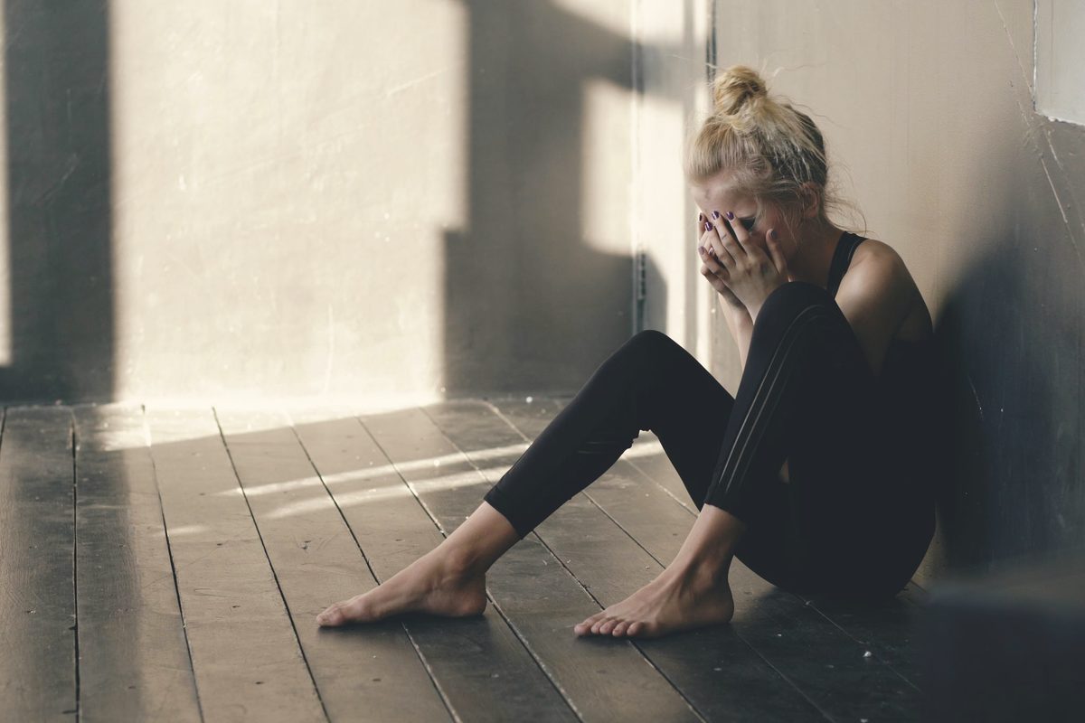 Woman sitting on the floor, upset