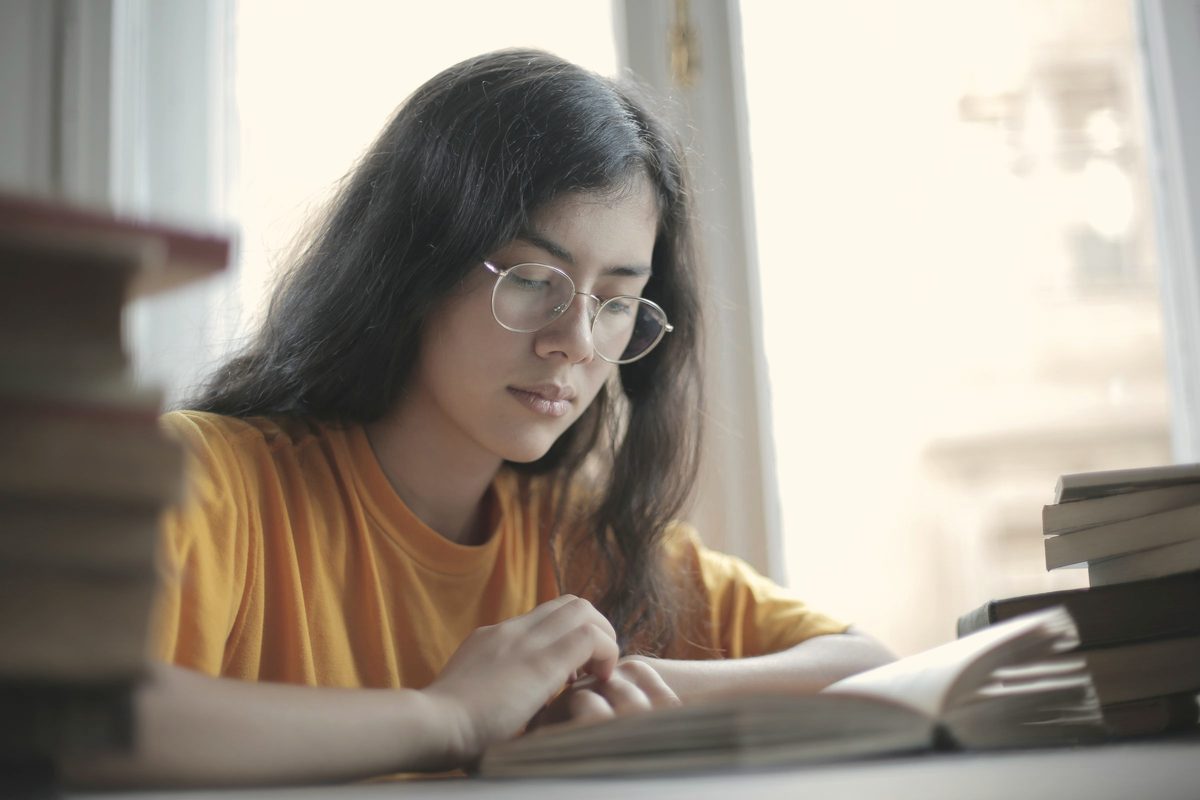 Student reading a book in a library