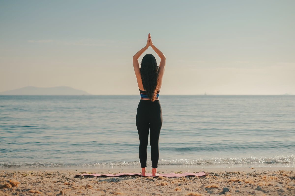 Woman stretching her arms overhead on the beach
