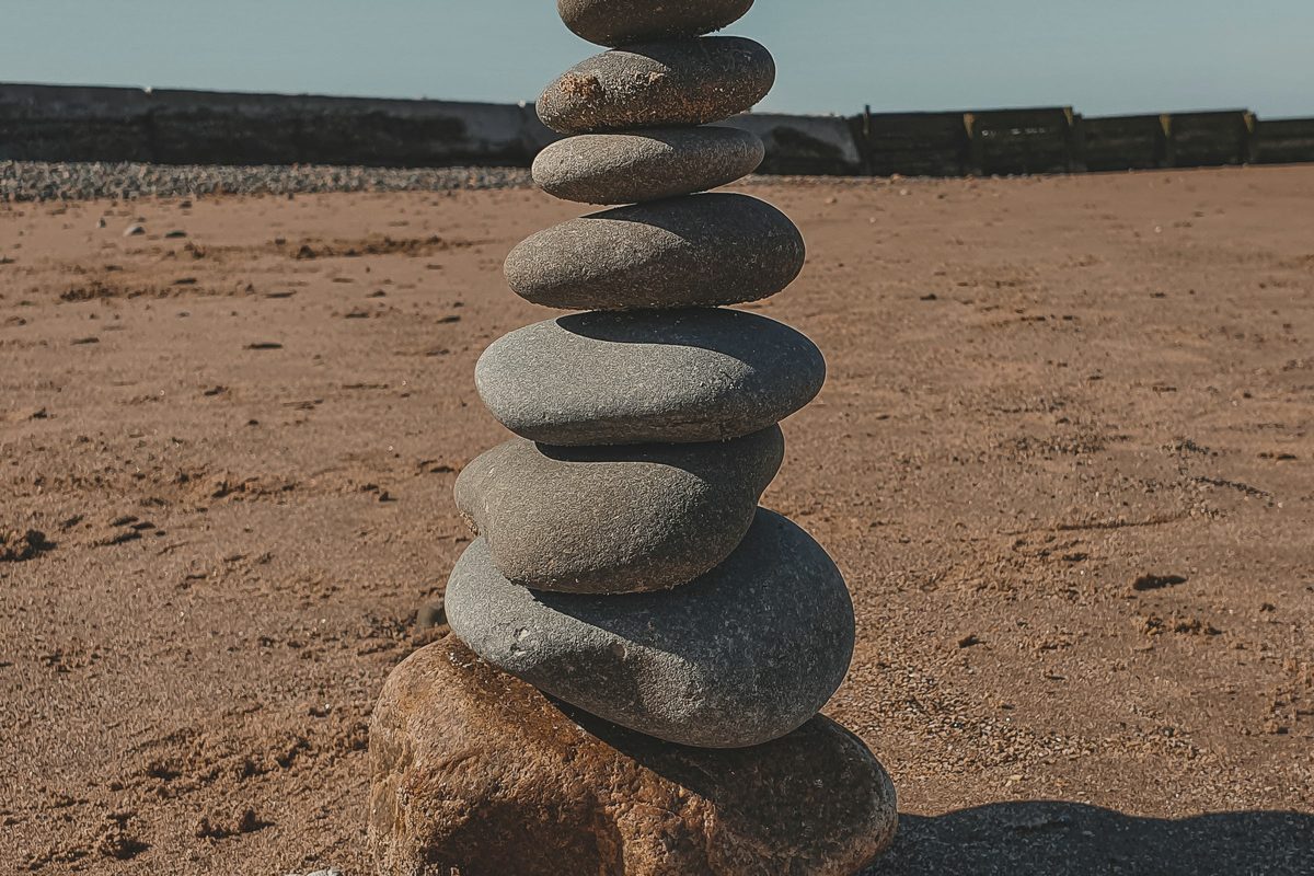 Smooth stones stacked on raked sand